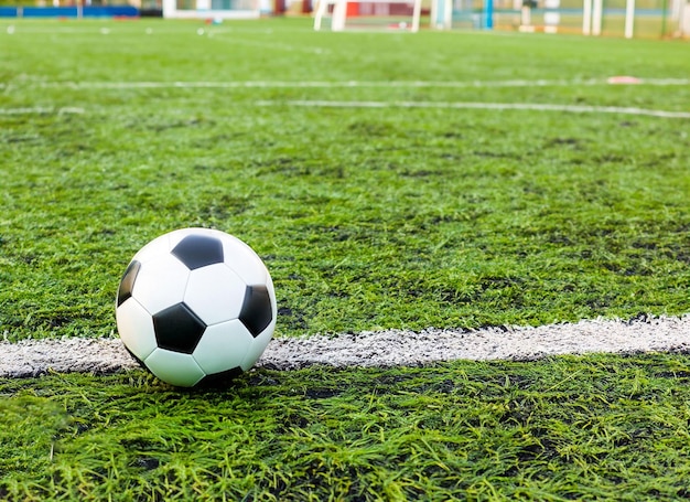 サッカー フィールド上のライン上にサッカー ボールが置かれています。 | プレミアム写真
