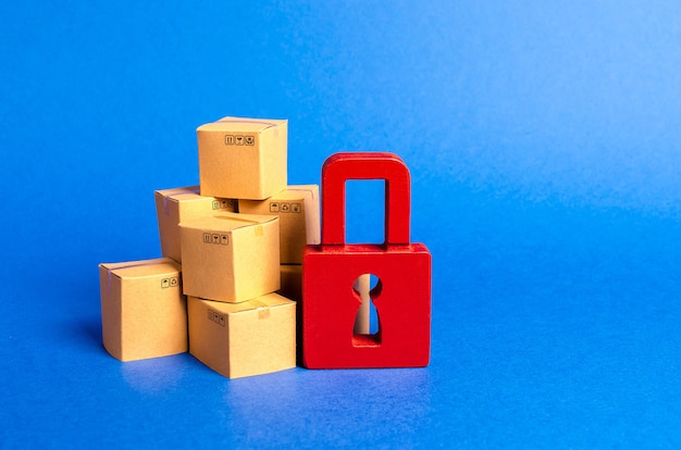 Фото Стопка картонных коробок и красный замок концепция страховых покупок