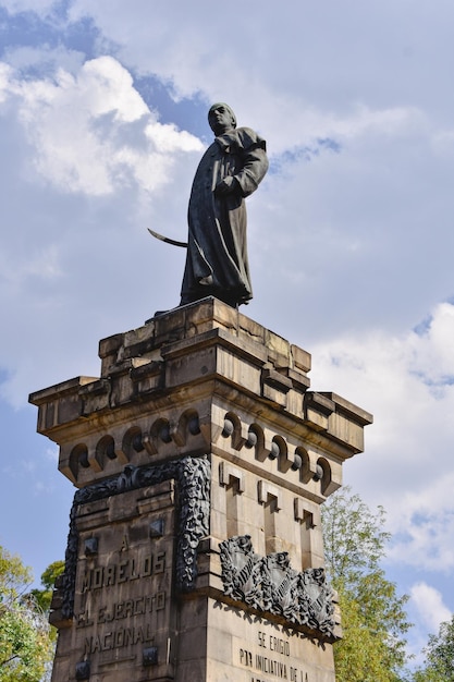 Фото Статуя святого на постаменте с птицей на нем