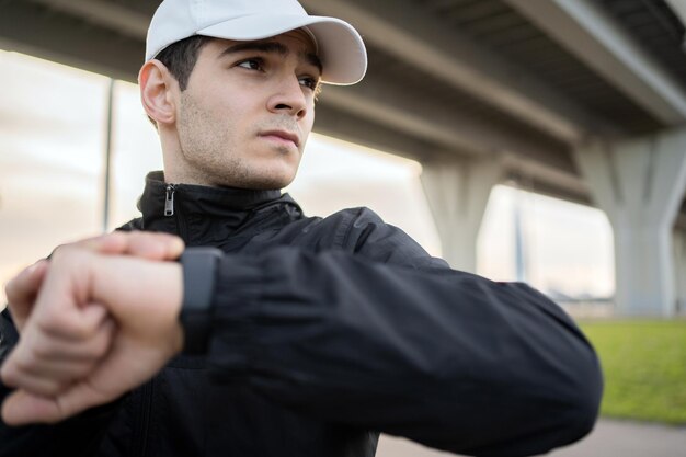 Фото Сильный спортсмен-мужчина использует умные часы для подсчета калорий и пульса