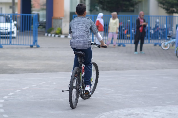 写真 学生が学校のフィールドで自転車に乗っています