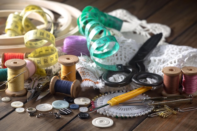 Фото Стол, полный швейных принадлежностей, включая швейную машину, ножницы и другие предметы.