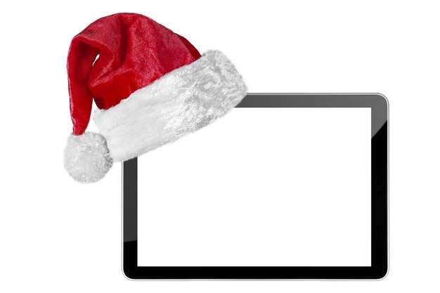 写真 白い背景のクリスマスのサンタクロースの帽子で隔離されたタブレットコンピュータ