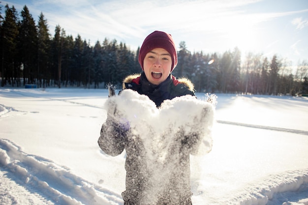 写真 10代の少年は、晴れた冬の日に森の中で雪で遊んでいます。幸せな冬季オリンピックと健康的なライフスタイル。