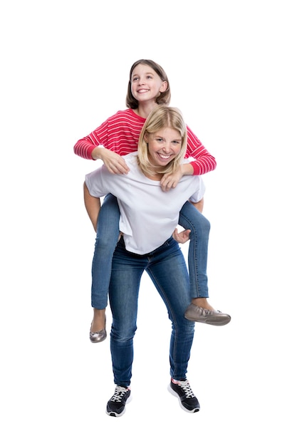 10 代の少女は母親が馬に乗っているのを見ている 彼らは抱き合ったり抱きしめたりしている 子供は赤い縞模様のセーターを着ている.