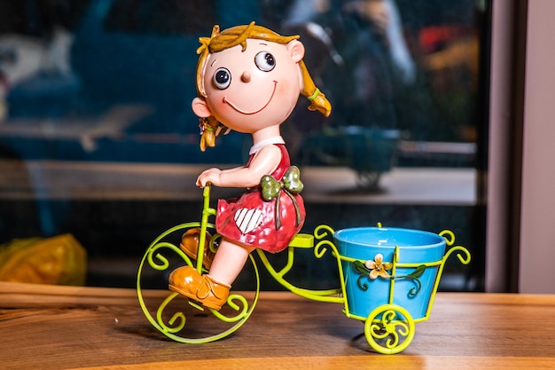 写真 青いバケツを持った自転車に乗った女の子のフィギュアです。