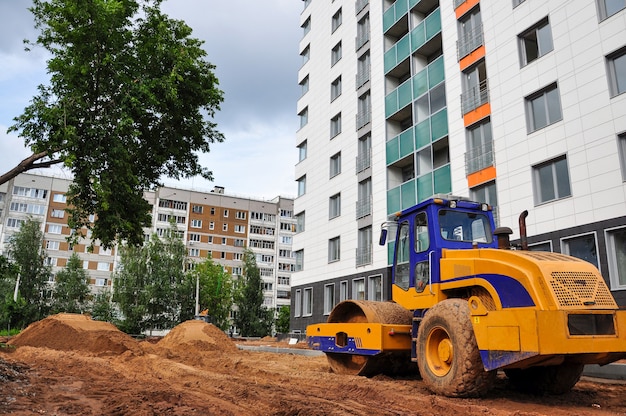 Фото Тракторный каток уплотняет почву для строительства новой дороги в дачном домике