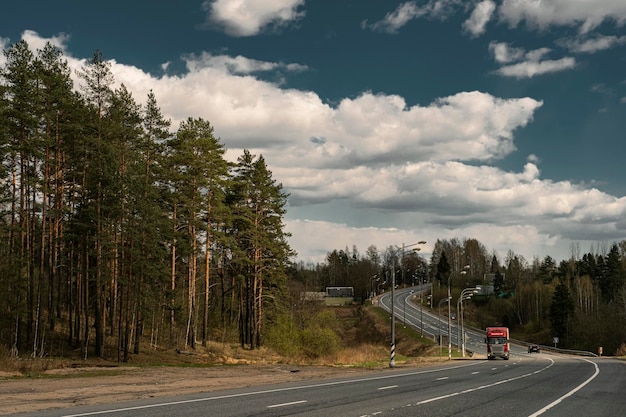 写真 曇り空を背景に道路を走るトラック