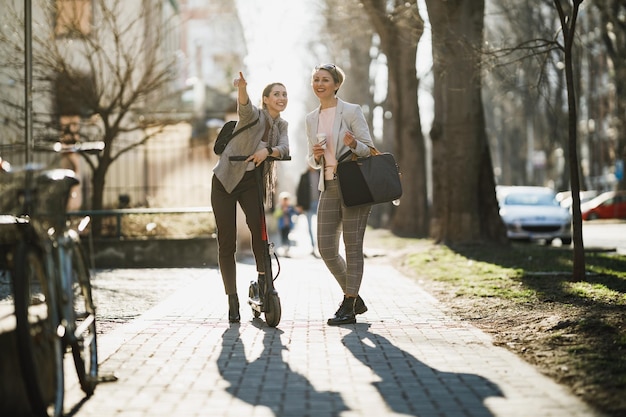 Фото Две успешные деловые женщины болтают во время прогулки по городу.