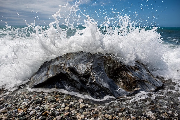 写真 岩だらけの海岸に波が打ち寄せています。