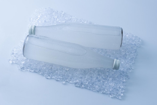 写真 分離された氷の上にソーダドリンクと白いボトル