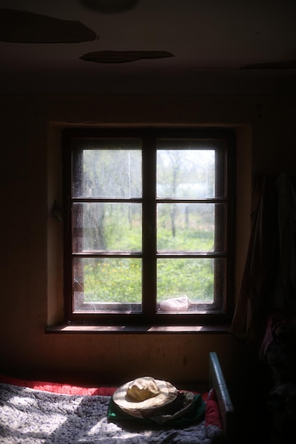 Фото Окно в темной комнате с солнцем, сияющим через окно.