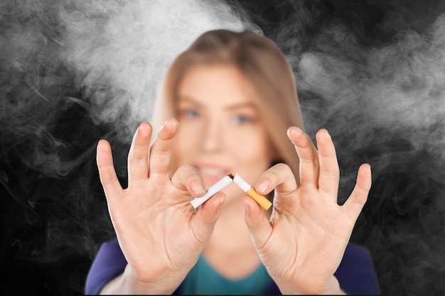写真 タバコを割る女性。コンセプト禁煙