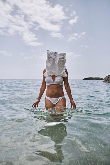 사진 머리에 가방을 고 바다에서 나오는 여자 재활용 개념
