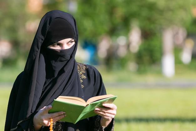 写真 東の女性が緑の草の上に公園に座って朝の祈りをします