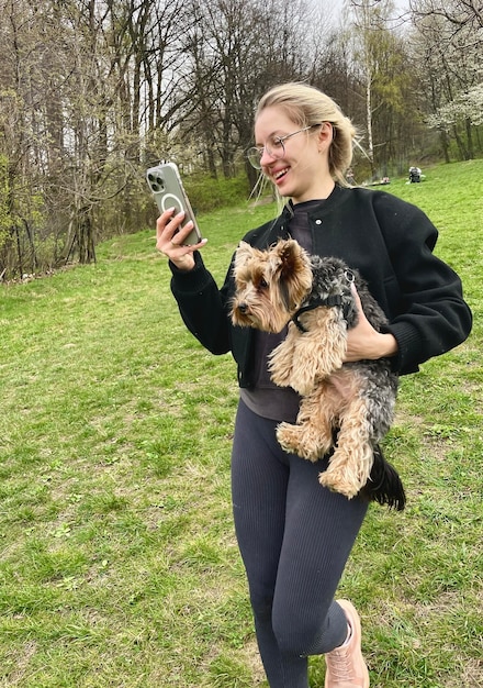 写真 犬と携帯電話を手に持っている女性