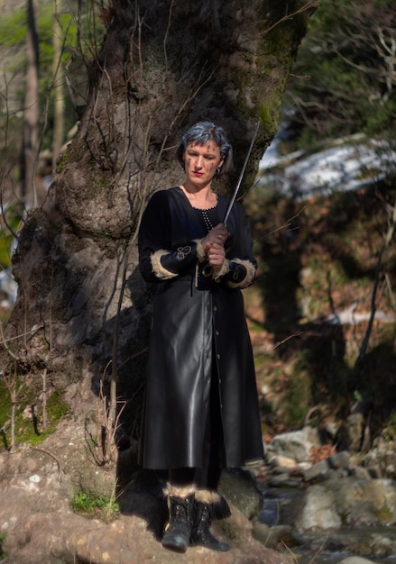 Фото Женщина в черном кожаном костюме с мечом в лесу