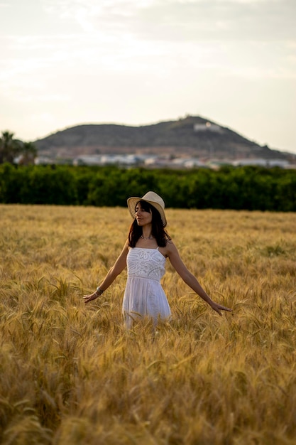 Фото Женщина в пшеничном поле смотрит в камеру