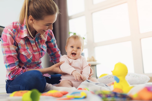 写真 ピンクのシャツを着た女性がリビングルームの床に座っています。