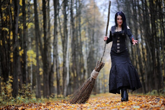 Фото Женщина в костюме ведьмы в густом лесу на ритуале