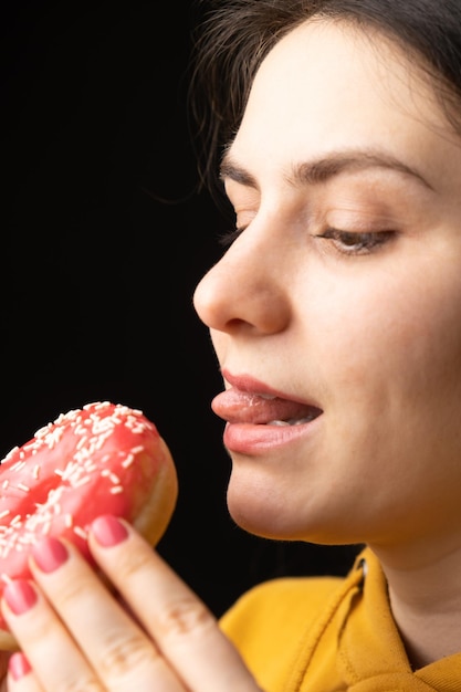 写真 ドーナツを食べようとする女性が匂いを嗅いで舐める