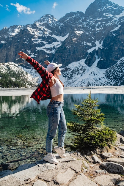 写真 モルスキオコタトラ山脈の湖のほとりに女性が立っている