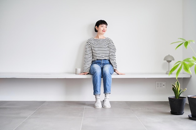 写真 観葉植物のある部屋でくつろぐ女性