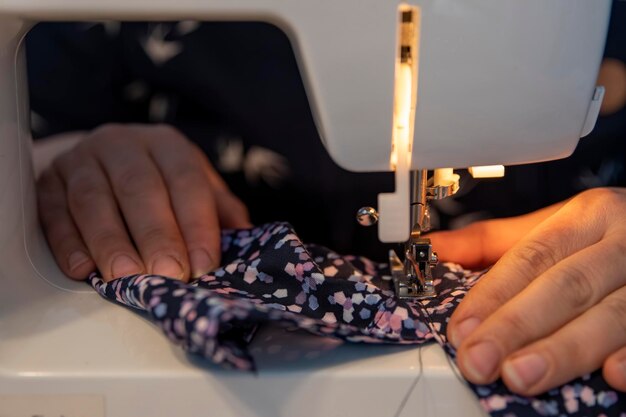Фото Женщина шиет и ремонтирует одежду на швейной машине дома