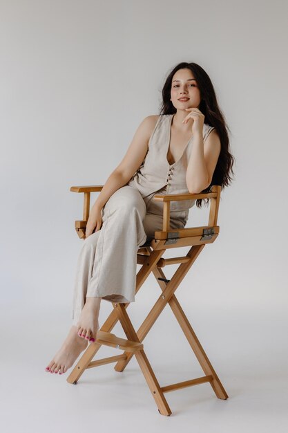 Фото Женщина сидит на стуле на белом фоне