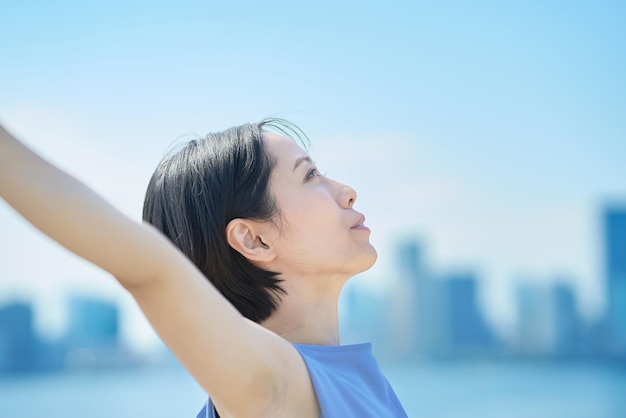 写真 青空の下、リラックスした表情の女性