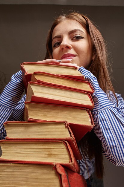 Фото Женщина со стопкой книг, которую она хочет изучать