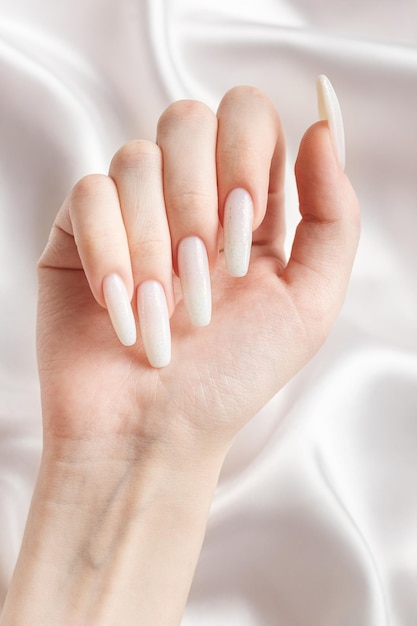 Фото Руки женщины с маникюром на них ногти окрашены в белый цвет