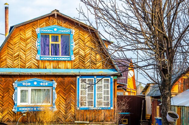 Фото Деревянный дом с синей отделкой и деревянной дверью.