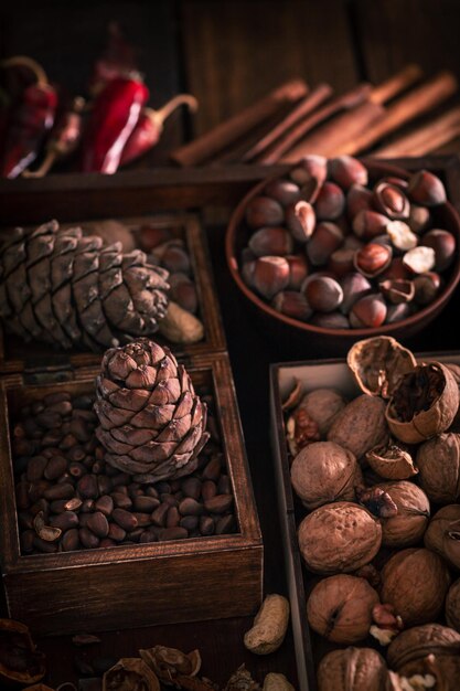 Фото Деревянный поднос с разными видами орехов. целые и измельченные орехи в разных ящиках, сложенных рядом