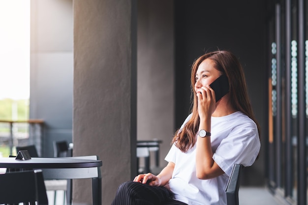 携帯電話で話している若いアジア人女性