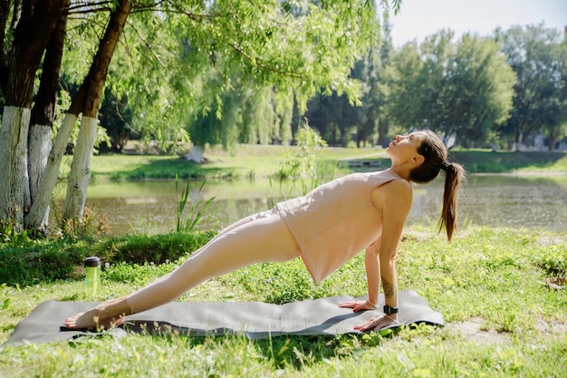 Фото Молодая привлекательная женщина занимается йогой и растягивается на открытом воздухе