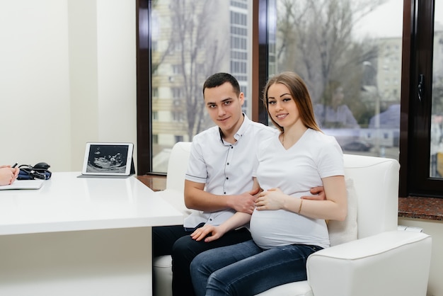 超音波検査後の婦人科医の診察で若いカップル。妊娠と健康管理