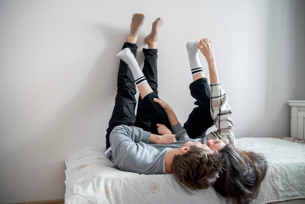 写真 若い夫婦がベッドに横たわってリラックスした愛情の瞬間を楽しんでいます