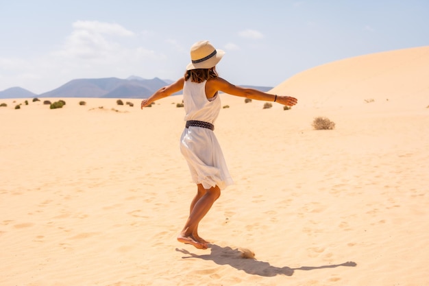 コラレホの砂丘を歩く帽子をかぶった若いヨーロッパ人観光客