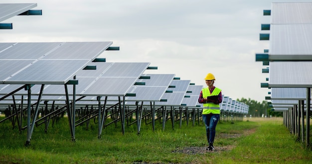 写真 若い女性の太陽電池エンジニアが一生懸命働いています。代替エネルギーでの作業太陽エネルギー