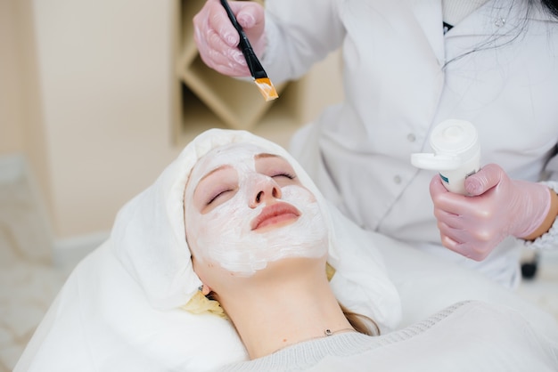 Молодая девушка в косметологическом кабинете проходит процедуру омоложения кожи лица. косметология.