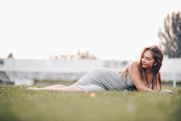 写真 若い女の子は女神のように草の上に横たわって、どこにも見ない休日の概念