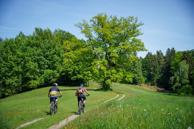 写真 オーストリアのクラゲンフルト近くのシングルトレイルでマウンテンバイクに乗っている若い女性と若い男性