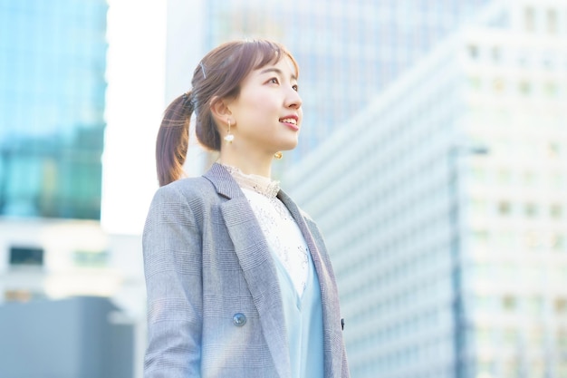 写真 街の空を見上げる若い女性