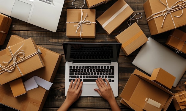 Foto a39's handen bereiden kartonnen dozen voor verzending met een laptop in de buurt