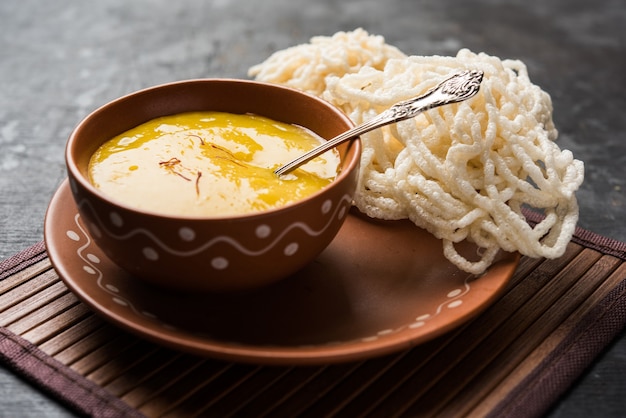 Aam Ras or Alphonso mango pulp with kurdai which is a fried dish made using wheat or gehu. selective focus