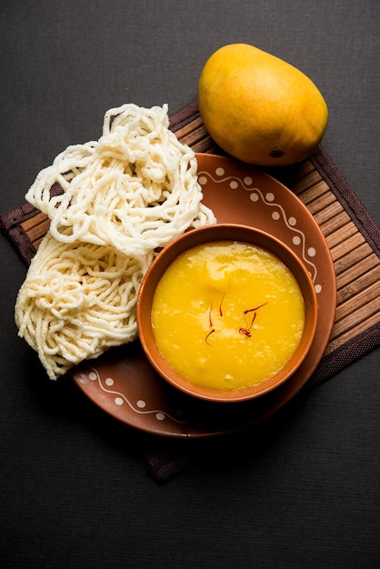 Aam Ras or Alphonso mango pulp with kurdai which is a fried dish made using wheat or gehu. selective focus