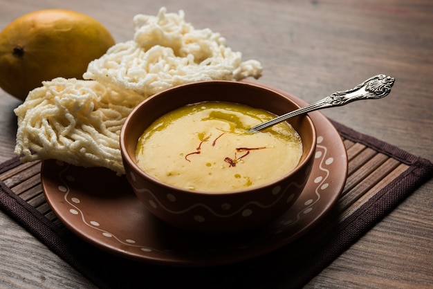 Aam Ras or Alphonso mango pulp with kurdai which is a fried dish made using wheat or gehu. selective focus