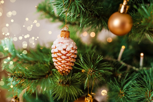 Aan de boom hangt een kerstboomspeelgoed in de vorm van een kegel