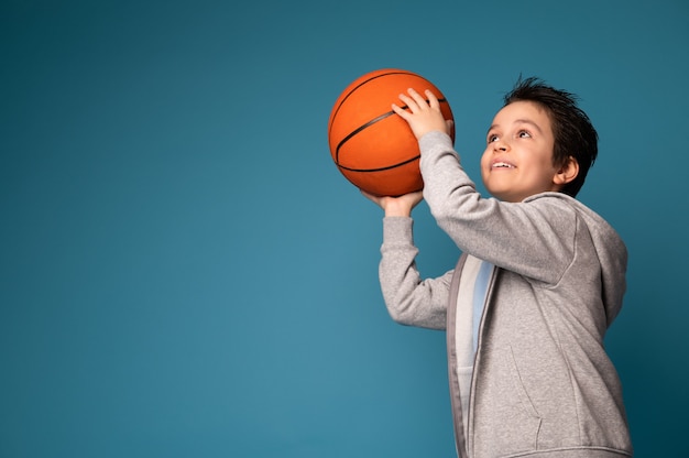 Aanbiddelijk Kaukasisch schooljongen die basketbal speelt